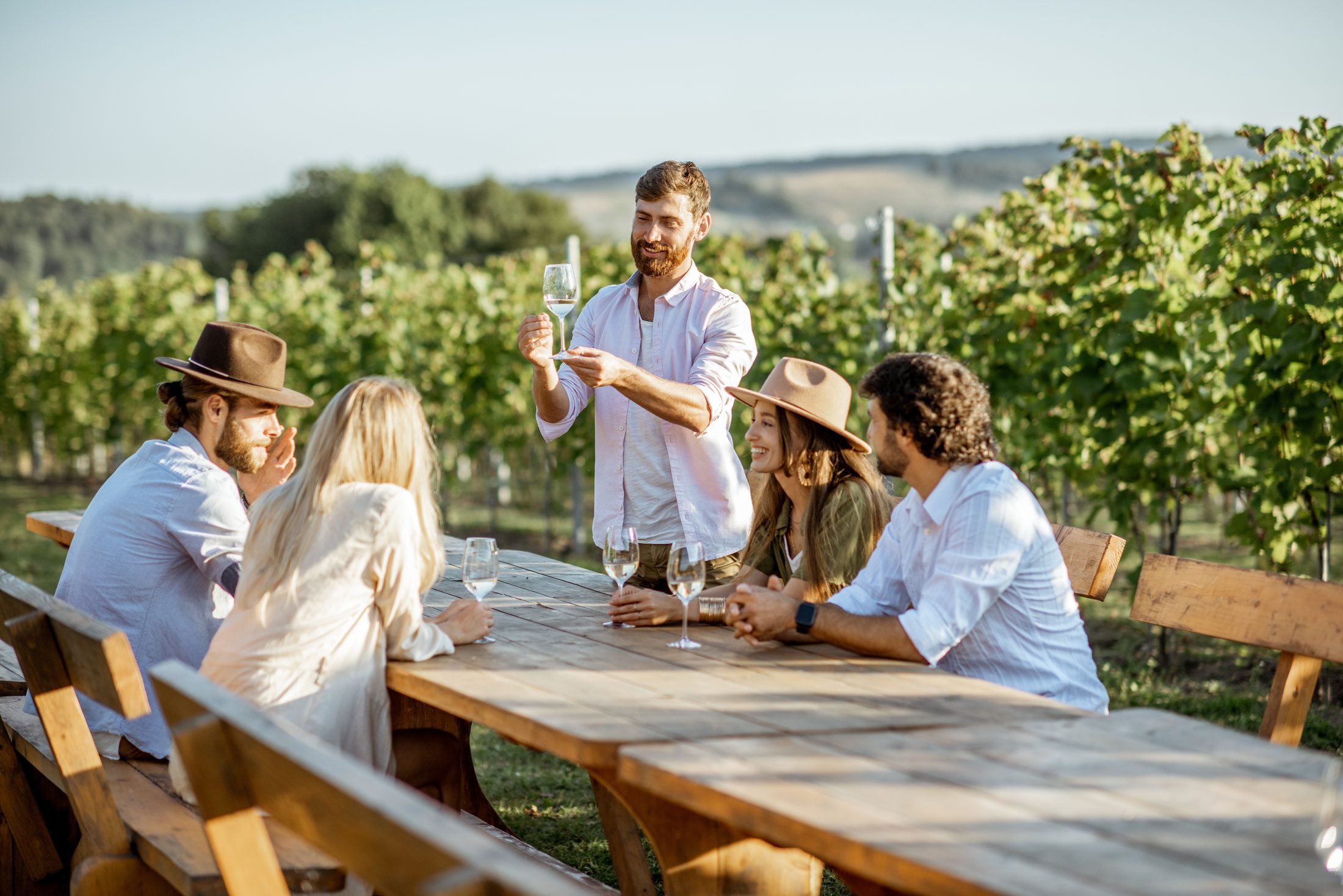 Grupo de viajantes fazendo degustação de vinho guiada em uma vinícola